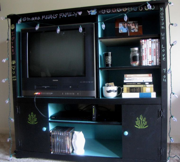 A used entertainment system painted with chalkboard paint and teal and lime-green accents.