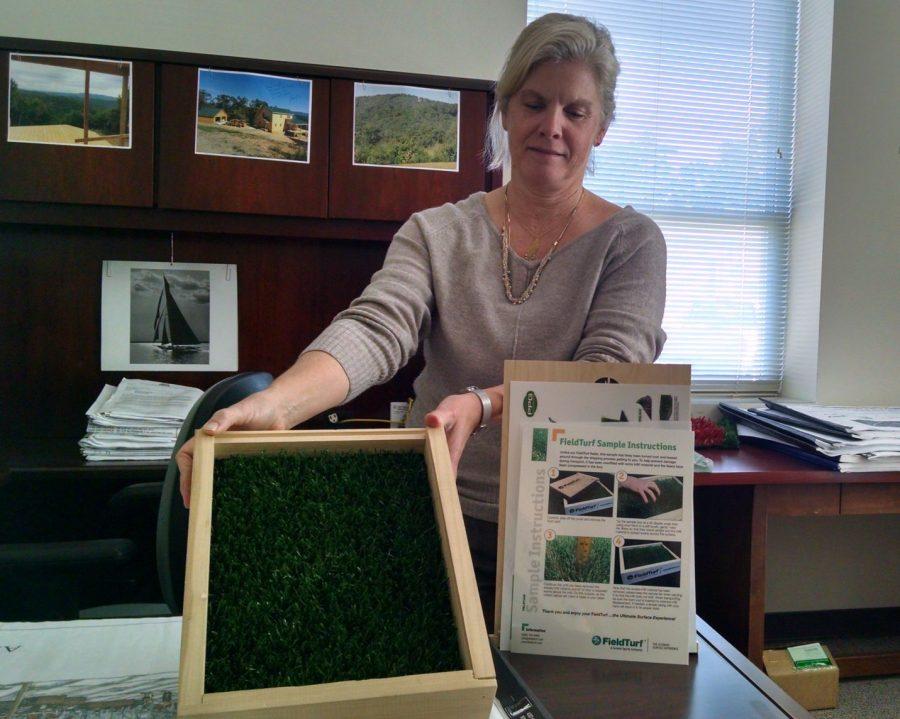 Facilities Structural Engineer Lisa Seifert displays a sample of artificial turf that UNCW is considering using for the installation of two oversized turf soccer fields in the intramural area on campus. 