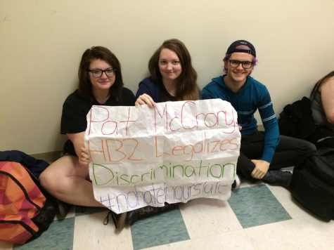 UNCW student protesters hold up homemade signs at the UNC system-wide bathroom sit-in against controversial House Bill 2.