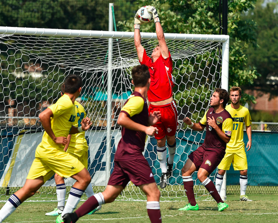 Ryan Cretens, in red, reaches up to save a shot sent by Winthrop late in Sundays match.