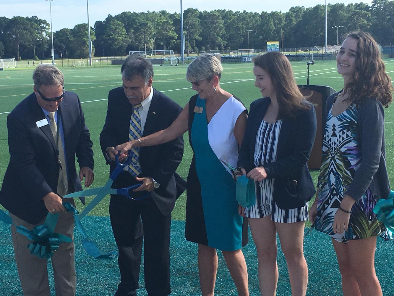 UNCW Chancellor Jose V. Sartartelli, center-left, cuts the ribbon during the grand-opening ceremony for the university's recreational fields.