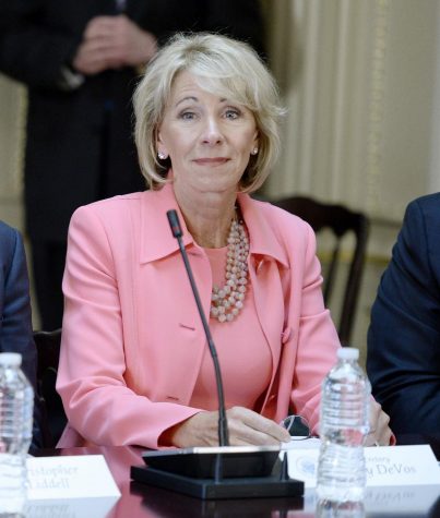 Education Sec. Betsy DeVos listens as U.S. President Donald Trump speaks during a strategic and policy discussion with CEOs in the State Department Library in the Eisenhower Executive Office Building on April 11, 2017, in Washington, D.C. DeVos has rescinded Obama-era guidelines on campus sexual assault. (Olivier Douliery/Abaca Press/TNS)
