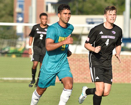 Julio Moncada, left, in UNC Wilmingtons match with High Point University.