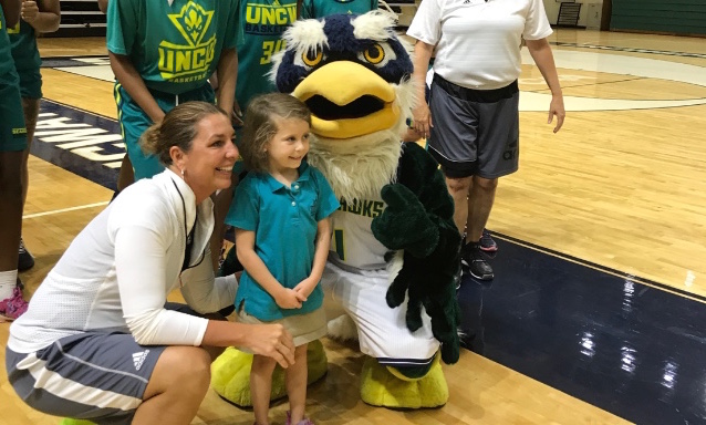 UNC Wilmington womens basketball coach Karen Barefoot, left, with six-year-old Violet Schwab, right, and Sammy C. Hawk.