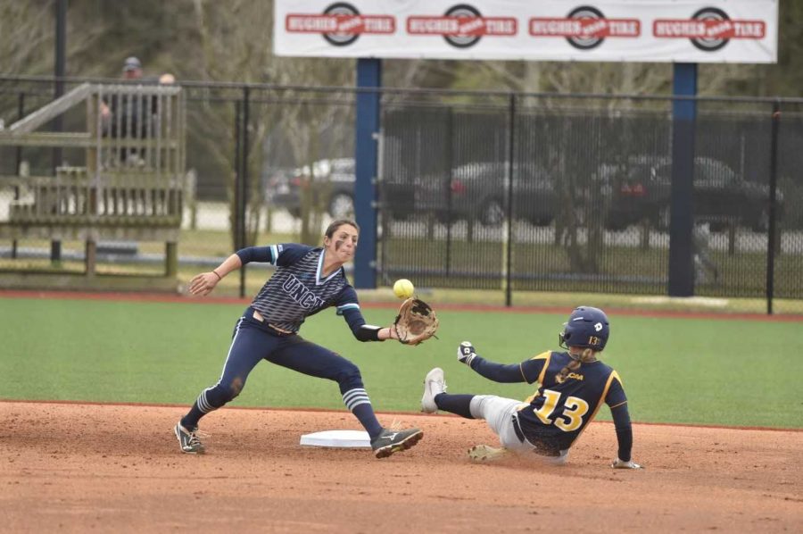 Kelsey+Bryan%2C+left%2C+attempts+to+tag+a+runner+at+second+base+in+a+UNC+Wilmington+softball+game.