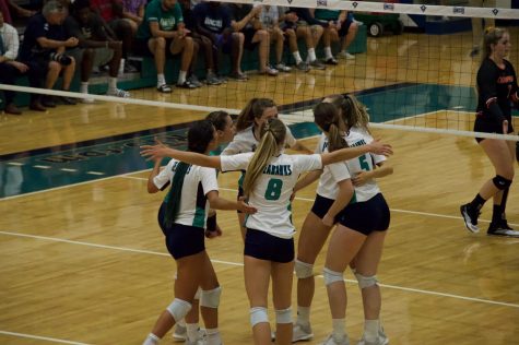 The UNCW volleyball team celebrates