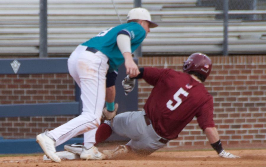 Cole Weiss (8) tags out Liam Bendo (5) during UNCWs season opener against St. Joseph on Feb. 15, 2019 at Brooks Field.