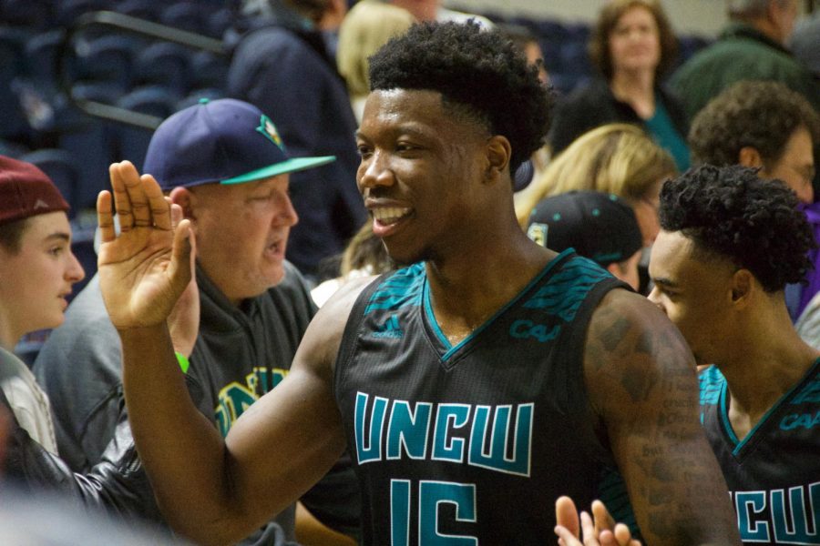 Devontae Cacok (15) celebrates with fans following UNCW's 87-79 Senior Night victory over Hofstra on Feb. 16, 2019.