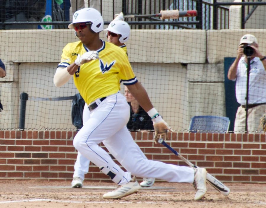 Greg Jones (2) singles and later scores Broadus Roberson (27) gets under a ball in left field during UNCW's game against William & Mary on March 30, 2019 at Brooks Stadium.