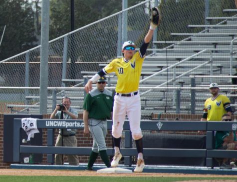 Brooks Baldwin (10) leaps for a ball thrown his way during UNCW's game against William & Mary on March 30, 2019 at Brooks Stadium.