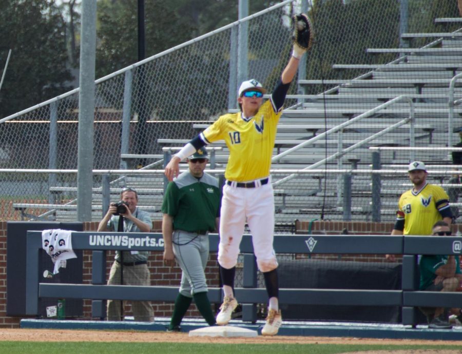 Brooks Baldwin (10) leaps for a ball thrown his way during UNCWs game against William & Mary on March 30, 2019 at Brooks Stadium.