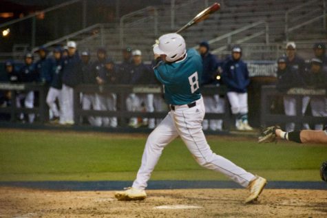 Cole Weiss (8) hits during UNCW's matchup against Toledo on Wednesday night at Brooks Field.