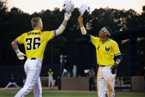 Kep Brown (36) and Greg Jones (2) celebrate following Brown's RBI homer during UNCW's matchup against Coastal Carolina at Brooks Field on March 26, 2019.