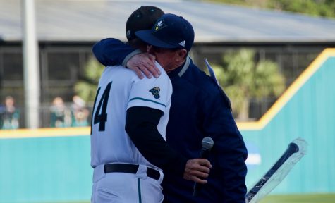 UNCW head coach Mark Scalf and Coastal Carolina head coach Gary Gilmore share a hug before Scalf's final matchup with the Chanticleers on March 27, 2019 at Springs Brooks Stadium.