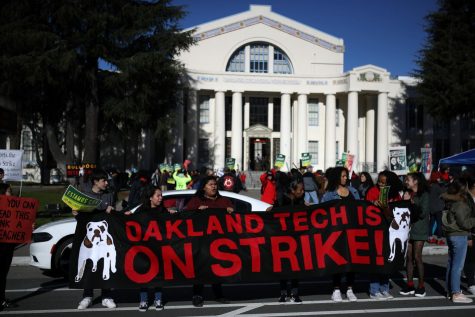 Oakland Unified School District students and teachers carry signs as they picket outside of Oakland Technical High School on February 21, 2019 in Oakland, California. Nearly 3,000 teachers in Oakland have gone on strike and are demanding a 12 percent retroactive raise.