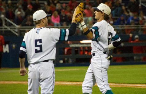Noah Liles (5) high-fives Noah Bridges (22) during UNCW's contest against N.C. State at Brooks Field on April 16, 2019.