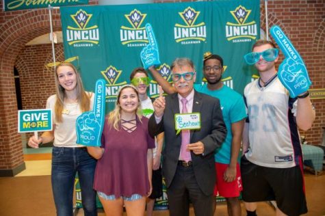 Chancellor Sartarelli, middle, and several students take photos during Give More in 24