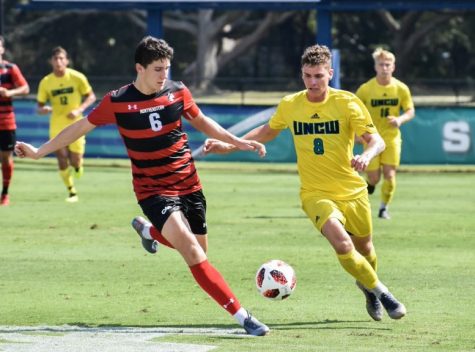 Mason Schuster (8) takes on a Northeastern defender during UNCW's matchup with the Huskies on Sep. 28, 2019.