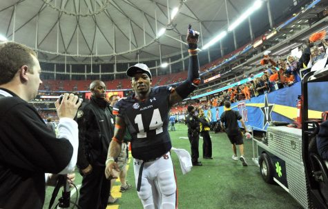 Auburn quarterback Nick Marshall (14) leaves the field as fans celebrate a 59-42 victory against Missouri in the SEC Championship game at the Georgia Dome in Atlanta, Saturday, Dec. 7, 2013.