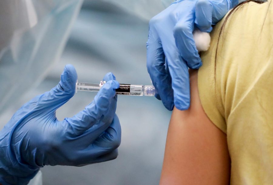 A nurse administers a flu vaccination shot to a woman at a free clinic held at a local library on October 14, 2020 in Lakewood, California. (Mario Tama/Getty Images/TNS)