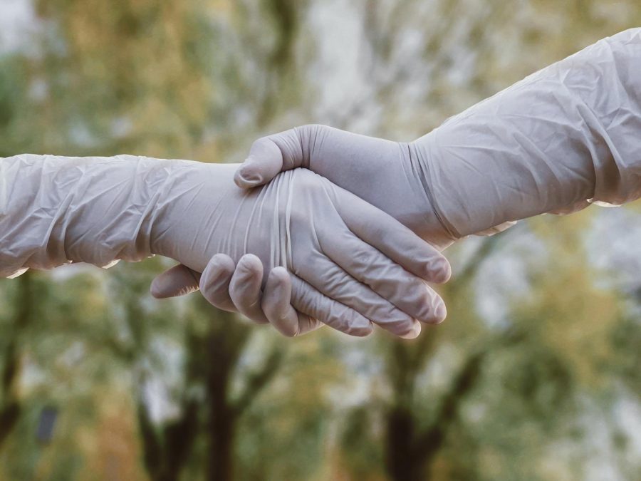 Shaking hands in gloves.
