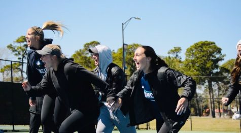 UNCW tennis team rushing the court after clinching the win vs Penn State.