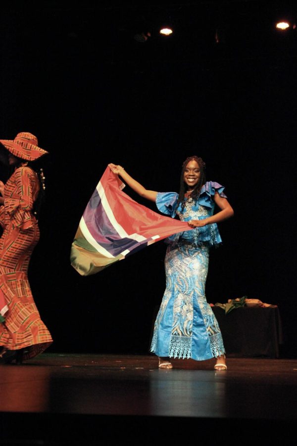 One student waves a Gambian flag in the scene titled “Africa Must Unite,” based on the novel 1963 novel by Kwame Nkrumah.