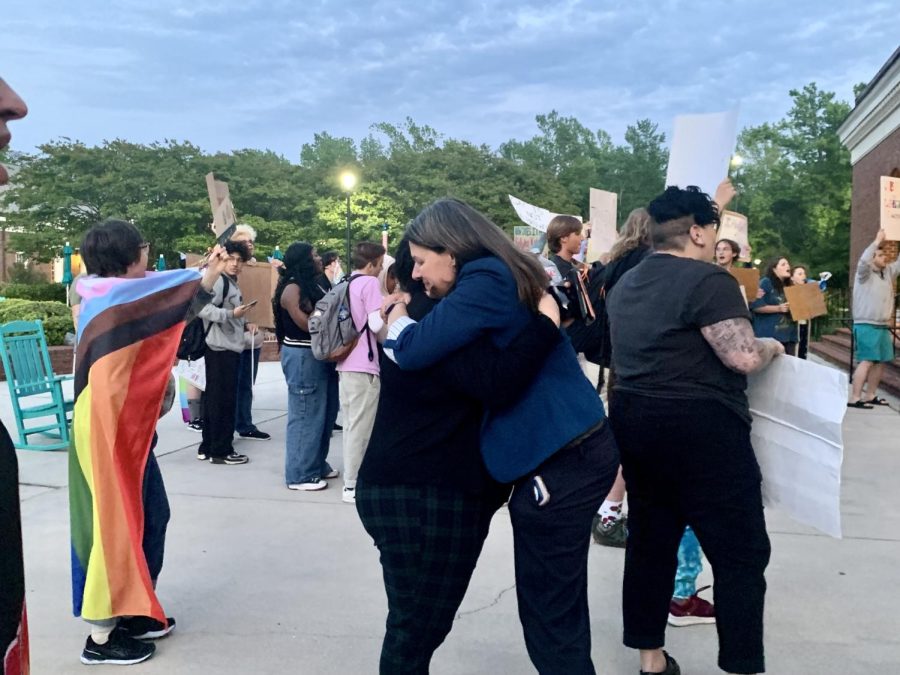 Two faculty members embrace surrounded by protesters outside the Burney Center. They walked out of the awards dinner as Sen. Michael Lee took to the stage. 
