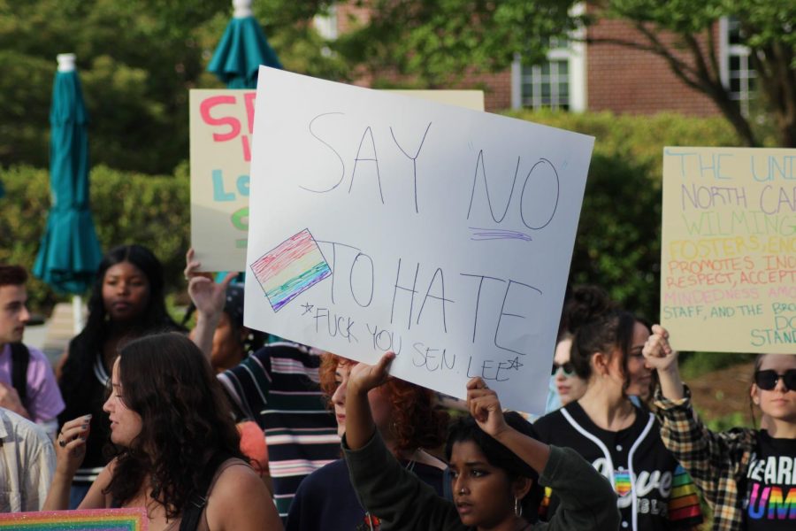 A student protester holds a sign outside of the Burney Center during the Razor Walker Awards ceremony. 