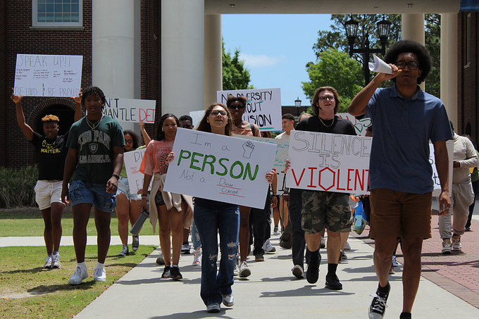 Students and faculty walking down Chancellors Walk shouting DEI cannot go! (Samantha Hill/The Seahawk)