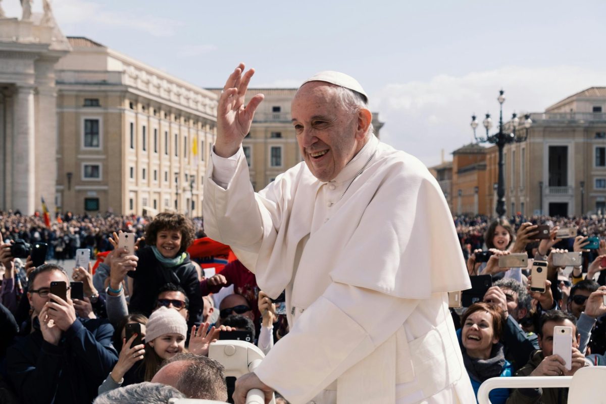 A photo of Pope Francis waving to a crowd of people (Ashwin Vaswani/Unsplash). 